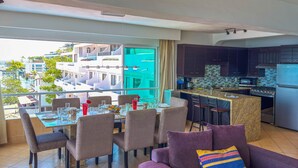 A modern living area with a dining table, chairs, a sofa, and a kitchen with a view. - Boana Torre Malibu #705 , Two bedrooms, Ocean view & City View, romantic zone (Amapas)