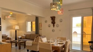 Un comedor con una mesa preparada para cuatro personas, un sofá y una silla.