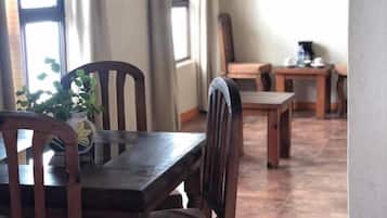 Un coin repas avec des meubles en bois, une table, des chaises et une plante en pot.