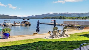 A lakeside dock with boats, chairs, and a fishing net.