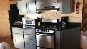 A compact kitchen with a stove, oven, and toaster.
