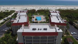 A hotel with a central pool, multiple parking lots, and a beach view. - Beachfront condo with direct pool & ocean view on St Augustine Beach (St Augustine Beach)