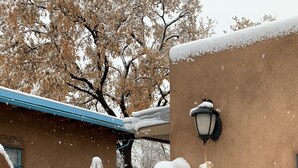 A snow-covered gate with a sign reading "Sunflower Northeast" and a wall-mounted lamp. - Beautiful Santa Fe downtown property walking distance to the Plaza (Santa Fe)