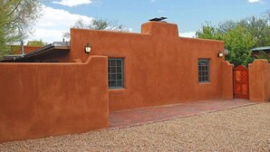 A stucco building with a red-tiled entrance and a solar panel on the roof. - Beautiful Santa Fe downtown property walking distance to the Plaza (Santa Fe)