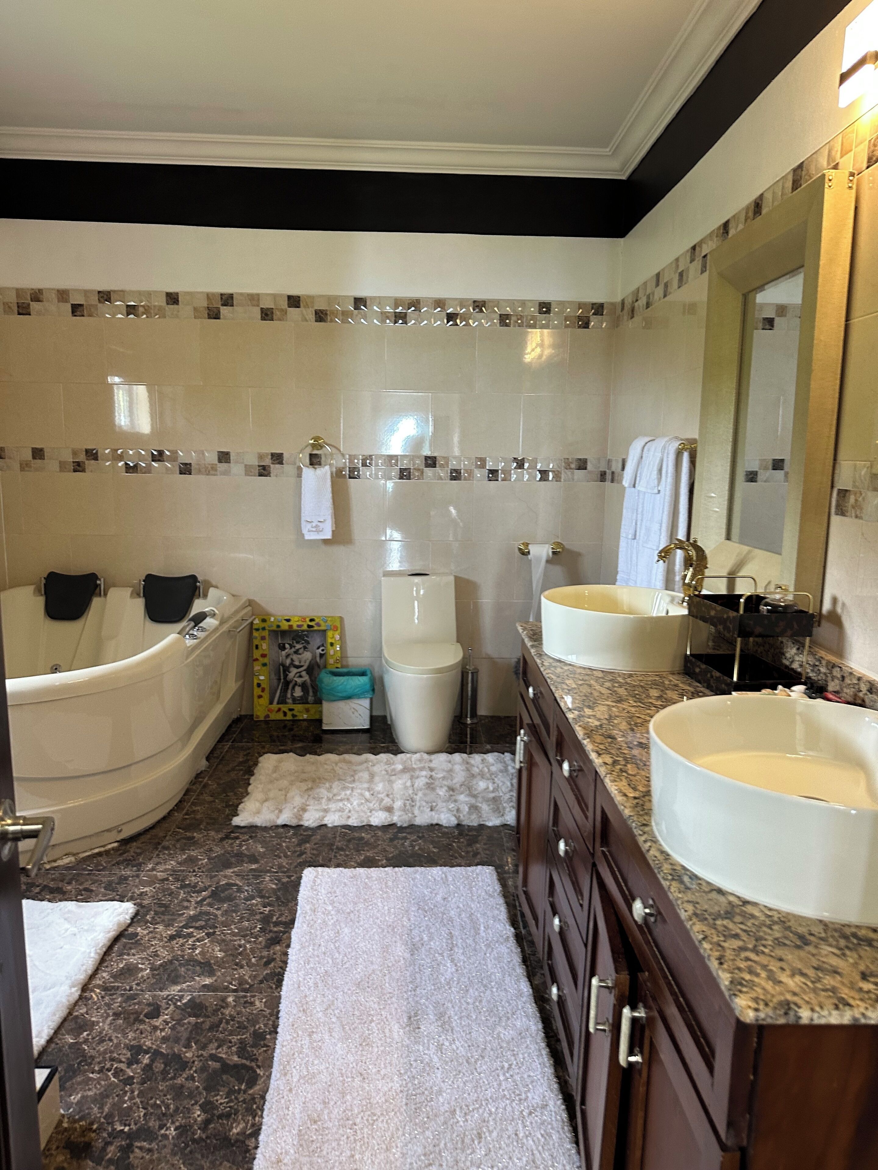 Ein Badezimmer mit Badewanne, Toilette, Waschbecken und Waschtisch.