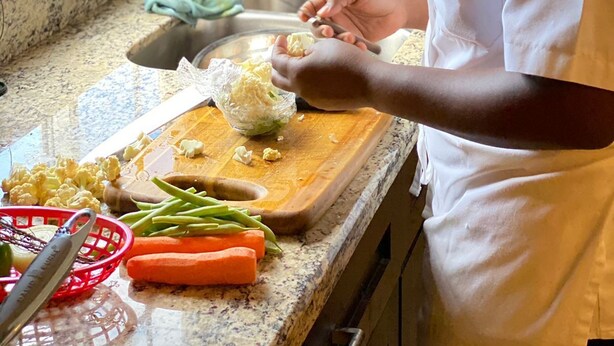 A kitchen with a granite countertop, a wooden cutting board, and various kitchen utensils. - Luxury ocean view villa  (Westmoreland)