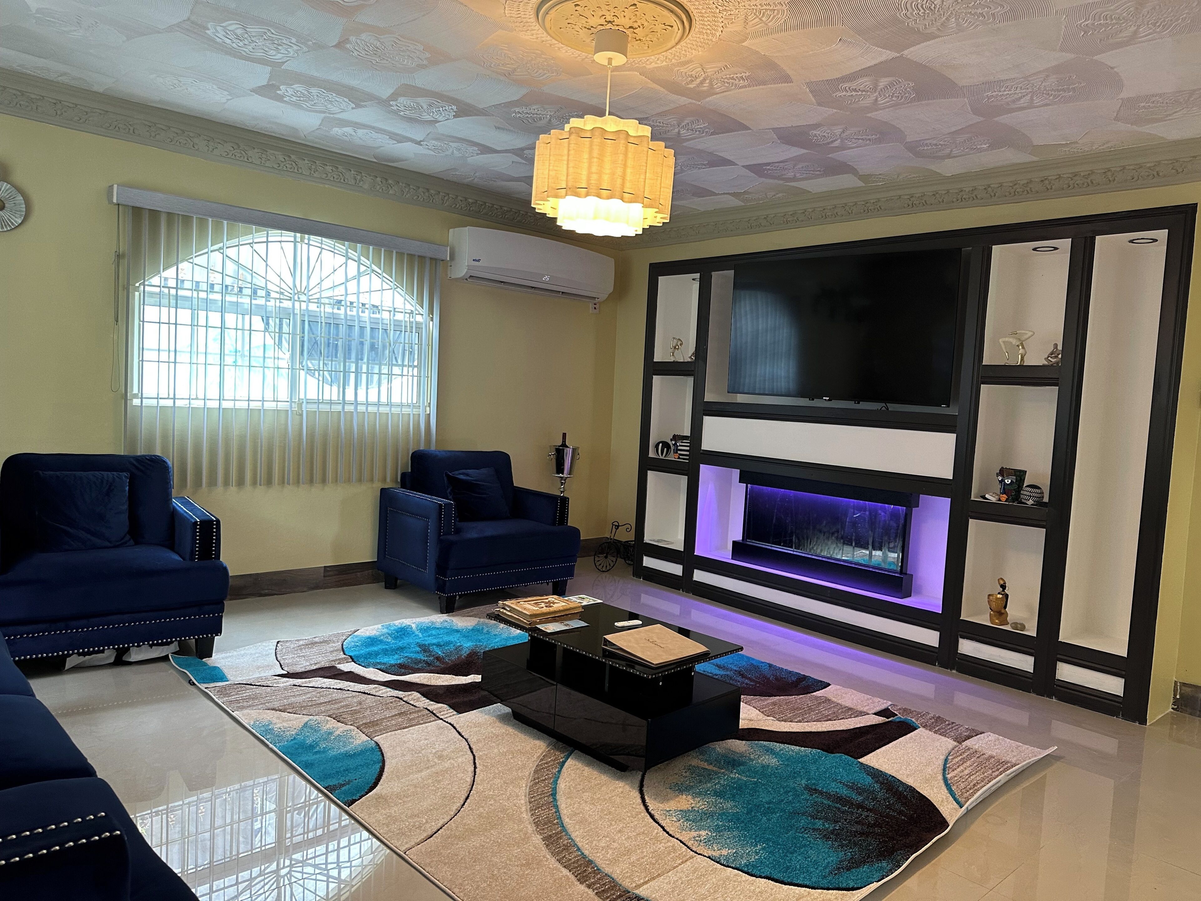 A living room with a fireplace, two sofas, a coffee table, and a TV.