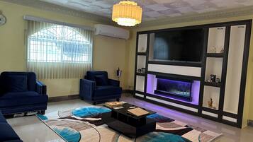 A living room with a fireplace, two sofas, a coffee table, and a TV.