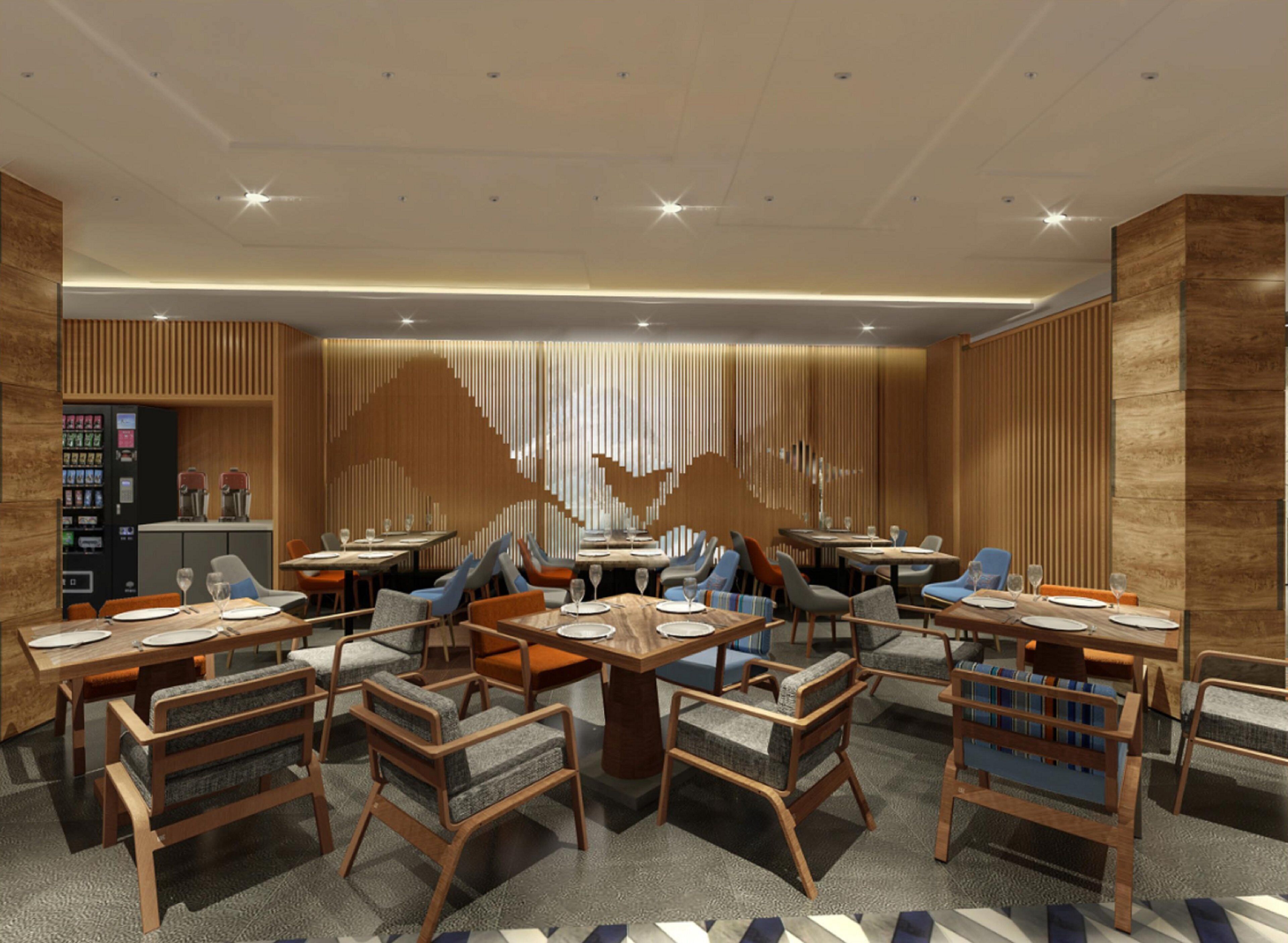 A modern dining area with multiple tables and chairs, a vending machine, and a decorative wall feature.