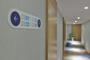 A hallway with a directional sign indicating room numbers and a directional arrow. - Holiday Inn Express Jiuzhaigou by IHG (Ngawa Autonomous Prefecture)