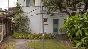 Stroll through the beautifully landscaped yard, featuring a variety of plants and flowers, and a pathway leading to the house.