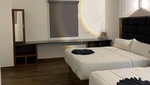 Une chambre d’hôtel moderne avec deux lits, une grande fenêtre, un bureau intégré et un luminaire au plafond.