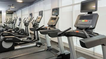 A row of treadmills with digital displays and a FlexDeck shock absorption system.