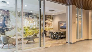 A modern office space with glass partitions, contemporary furniture, and a large abstract mural on the wall. - Courtyard by Marriott Asheville Biltmore Village (Asheville)