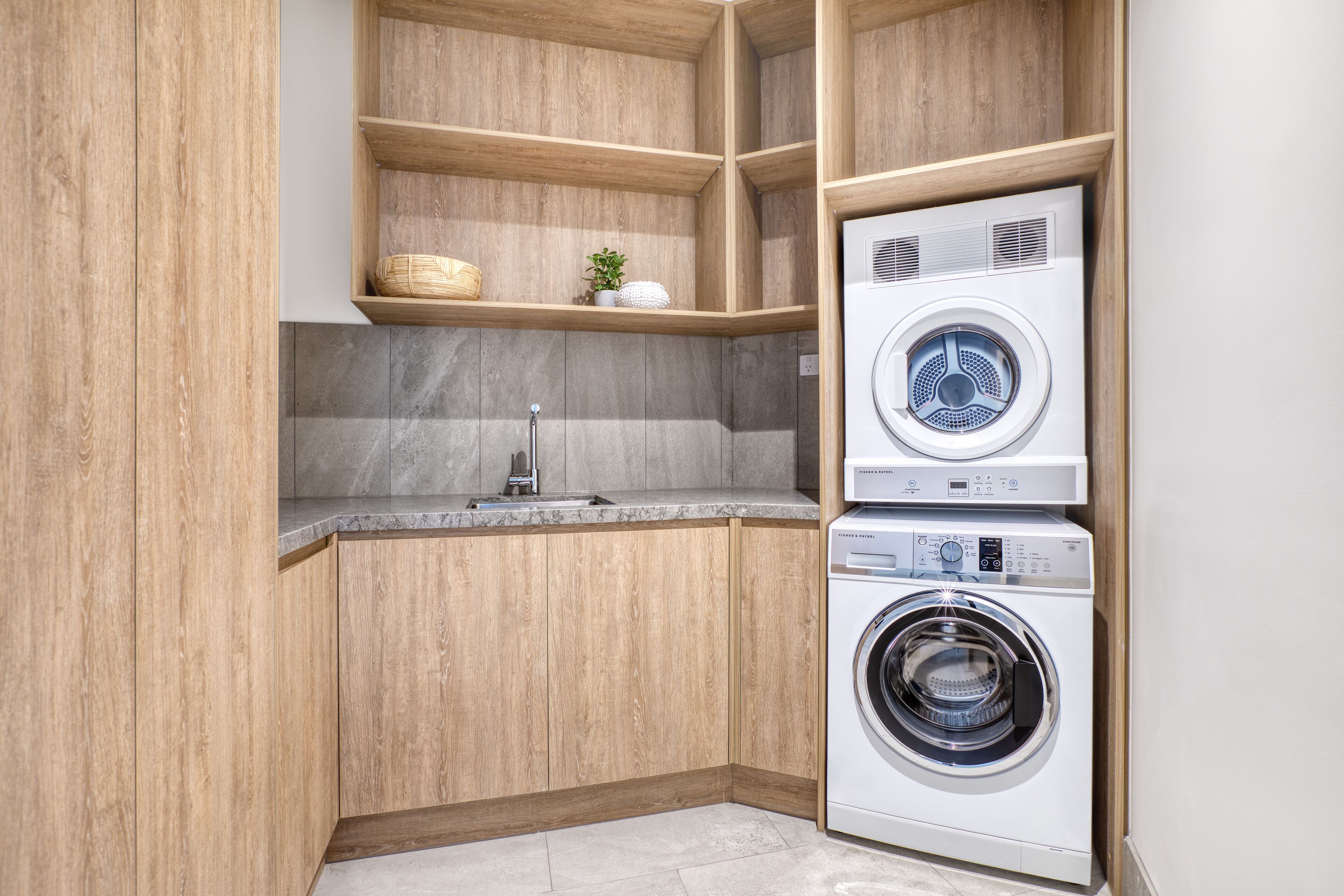 A laundry room with wooden cabinets, a washing machine, and a dryer.