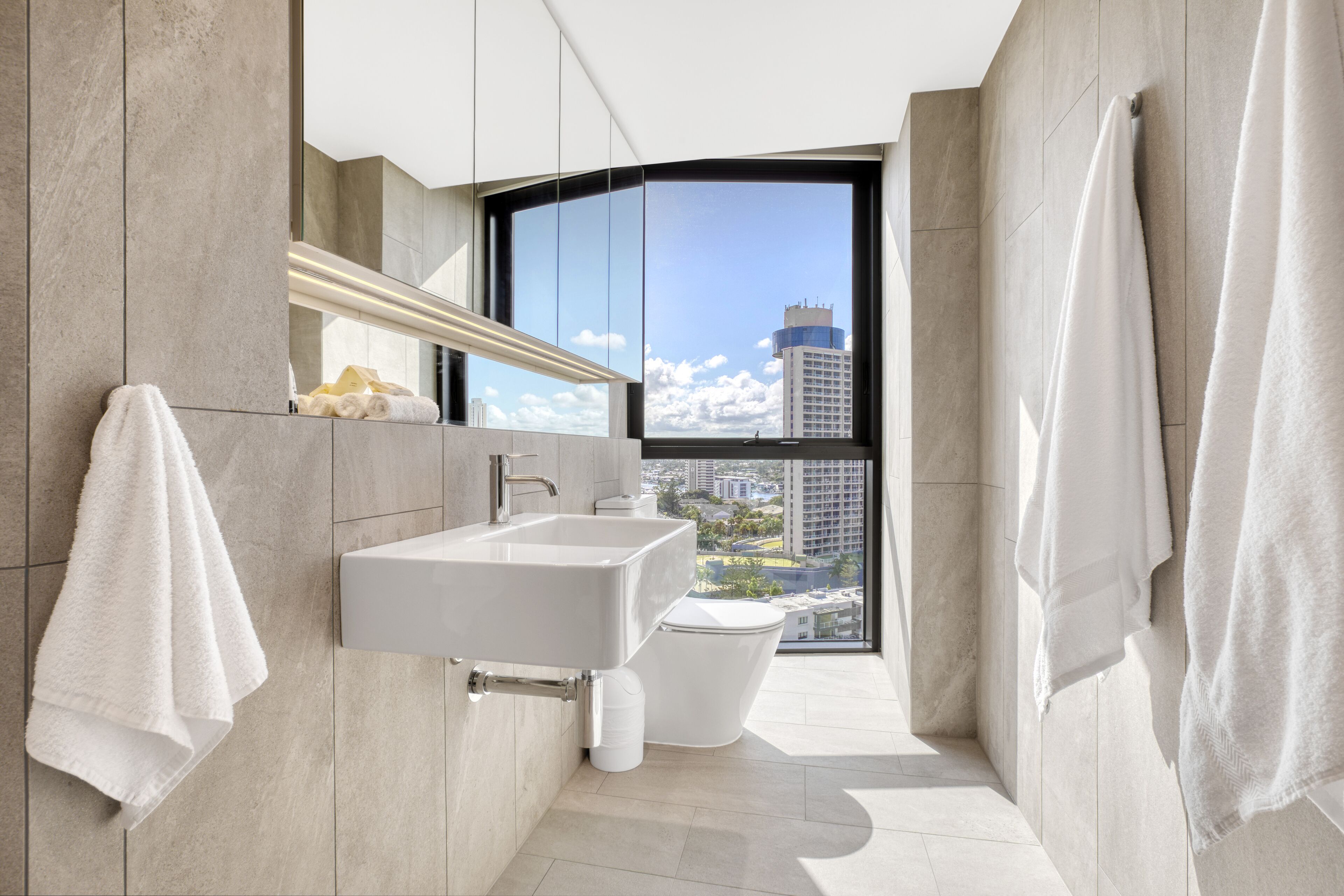 Un bagno moderno con una grande finestra, un lavandino e un water.