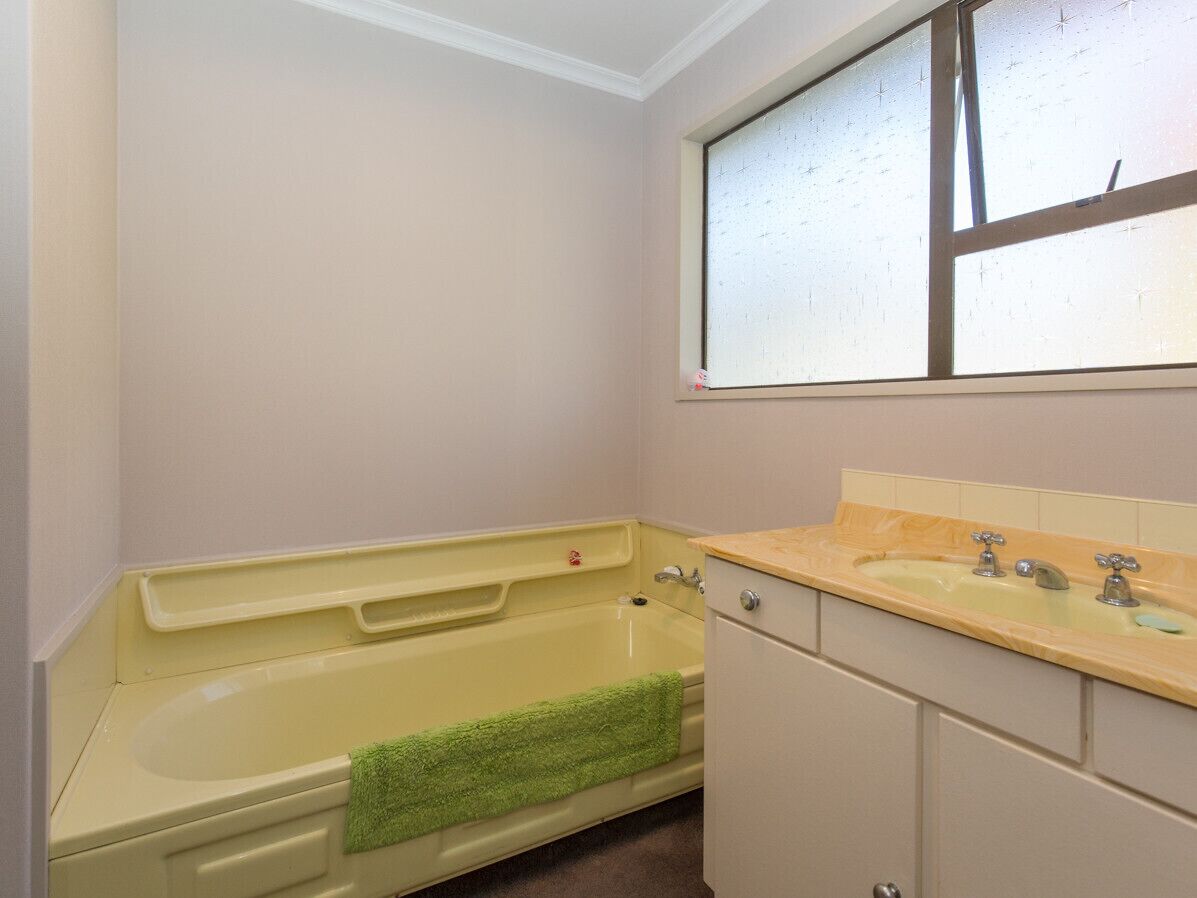 A bathroom with a bathtub, a sink, and a window.