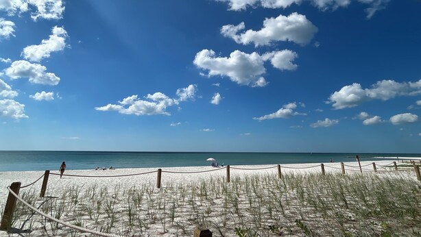 A beach with a clear sky and a rope barrier. -   Healthy, relaxing , romantic , organic vacation                   - (Naples)