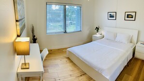 A bedroom with a large bed, a desk, and a window with blinds. -   Healthy, relaxing , romantic , organic vacation                   - (Naples)