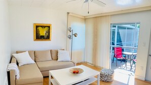 A living room with a beige sofa, white coffee table, and a painting on the wall. -   Healthy, relaxing , romantic , organic vacation                   - (Naples)