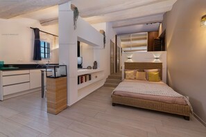 Un dormitorio moderno con una cama grande, un escritorio empotrado y una escalera que conduce a un nivel superior.