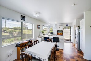 Una cocina moderna con comedor, ventanas amplias y vistas al exterior.