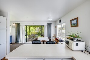 A modern kitchen with a dining area, a microwave, and a view of the outdoors.