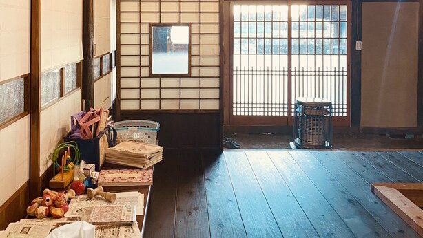 Una habitación japonesa tradicional con suelo de tatami, puertas correderas shoji y techo de madera.
