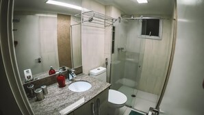 Ein kleines Badezimmer mit Waschbecken, Toilette und Dusche.