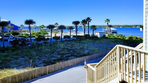 A beachfront property with a wooden deck, a pool, and a view of the ocean.