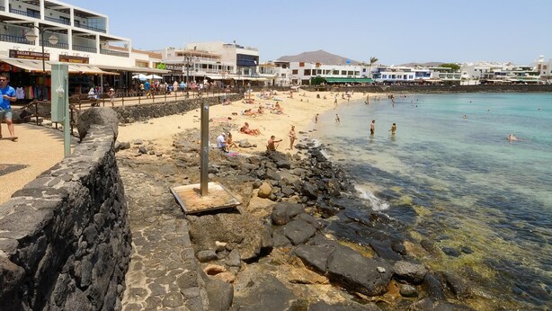 A beachside hotel with a stone wall, a sandy beach, and clear turquoise water. - Apartment Lima Center Playa Blanca By PVL (playa blanca)