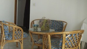 A dining area with wicker furniture and a glass table, featuring a coastal painting on the wall. - Apartment in Kustici with Balcony, WIFI, Washing machine (4847-1) (Kustici)