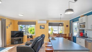 A modern apartment with a living area, dining space, and kitchenette.