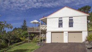 Une maison de plain-pied avec un garage, une véranda et une cour clôturée.