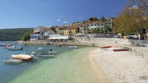 Une ville côtière aux eaux cristallines, où l’on peut admirer des bateaux et des bâtiments aux couleurs vives.