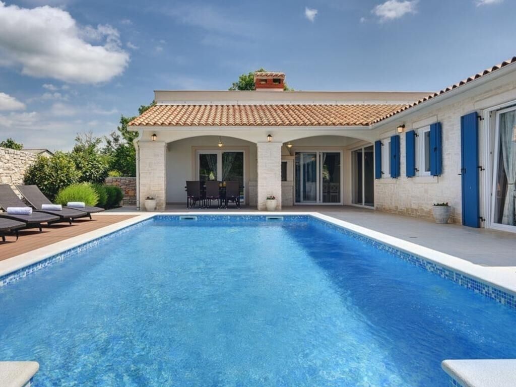 Piscina com espreguiçadeiras e um espaço de terraço.