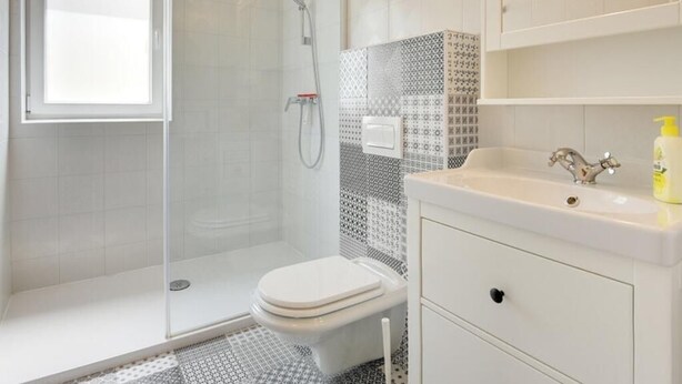 Une salle de bain moderne avec une douche à parois de verre, des toilettes et un lavabo avec un miroir.
