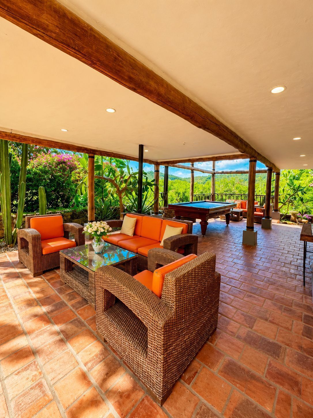 An outdoor patio with wicker furniture and a pool table.