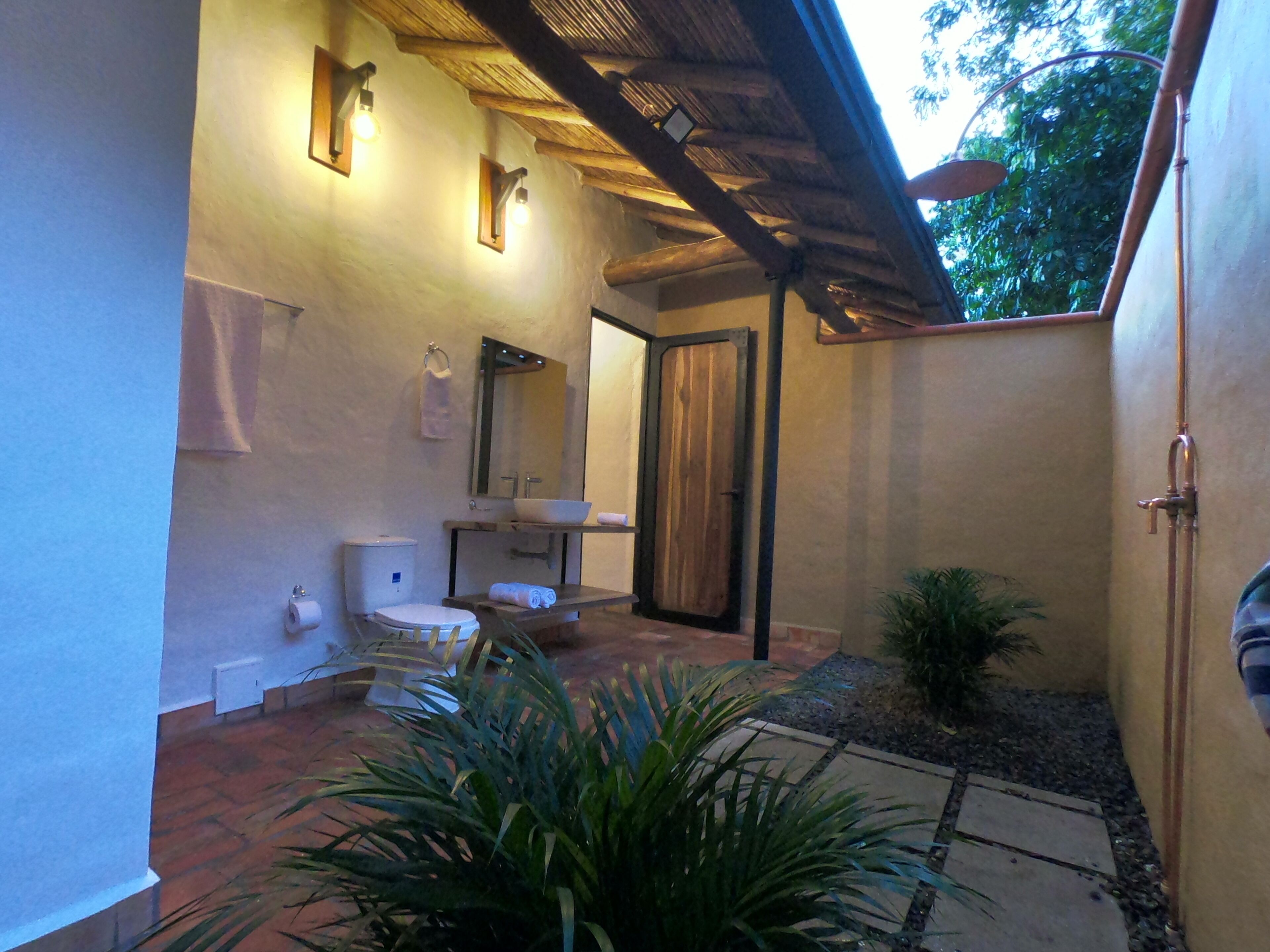 Une salle de bain comprenant des toilettes, un lavabo et un espace douche.