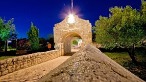 An ancient stone archway with a light source above it, leading to a pathway surrounded by greenery. - Apartment in Nin with Loggia, Air condition, WIFI (4869-5) (Nin)