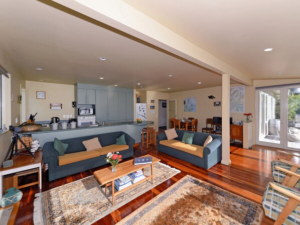 A spacious living area with a kitchen, two sofas, a coffee table, and a rug.
