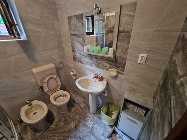A bathroom with a toilet, bidet, sink, and a small trash bin. - Apartment in Ičići with Seaview, Terrace, WIFI (4870-3) (Icici)