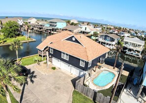A residential property with a swimming pool, a dock, and a view of the water.