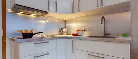 Een koelkast, een oven, een kookplaat, een koffiezetapparaat/waterkoker