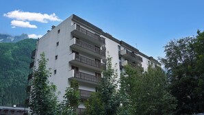 A multi-story building with balconies, surrounded by trees and mountains. - Apt Le Concordia 4 Chic 2BR in Chamonix Centre | Ski, Chamonix, France (Chamonix)