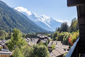 A mountain village with traditional wooden houses, a clear sky, and snow-capped peaks in the background. - Résidence Androsace 53, Argentière (Chamonix), France (Argentière (Chamonix))