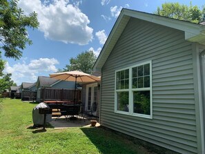 A single-story house with a covered patio area, a barbecue grill, and a small deck. - GET AWAY FROM IT ALL - Cottage 28 Taylorsville Lake (Taylorsville)