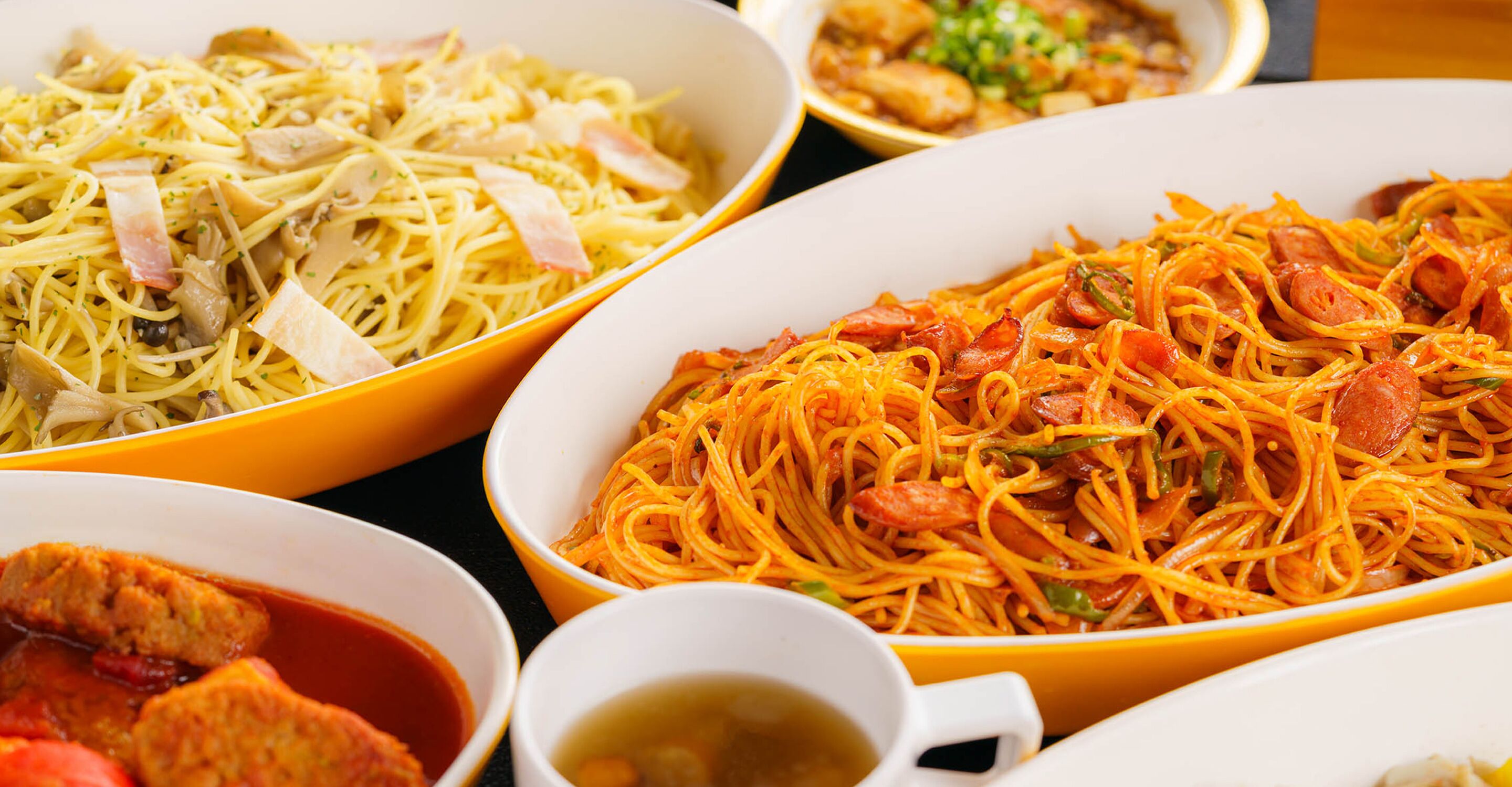 Three bowls of spaghetti with different sauces and garnishes.