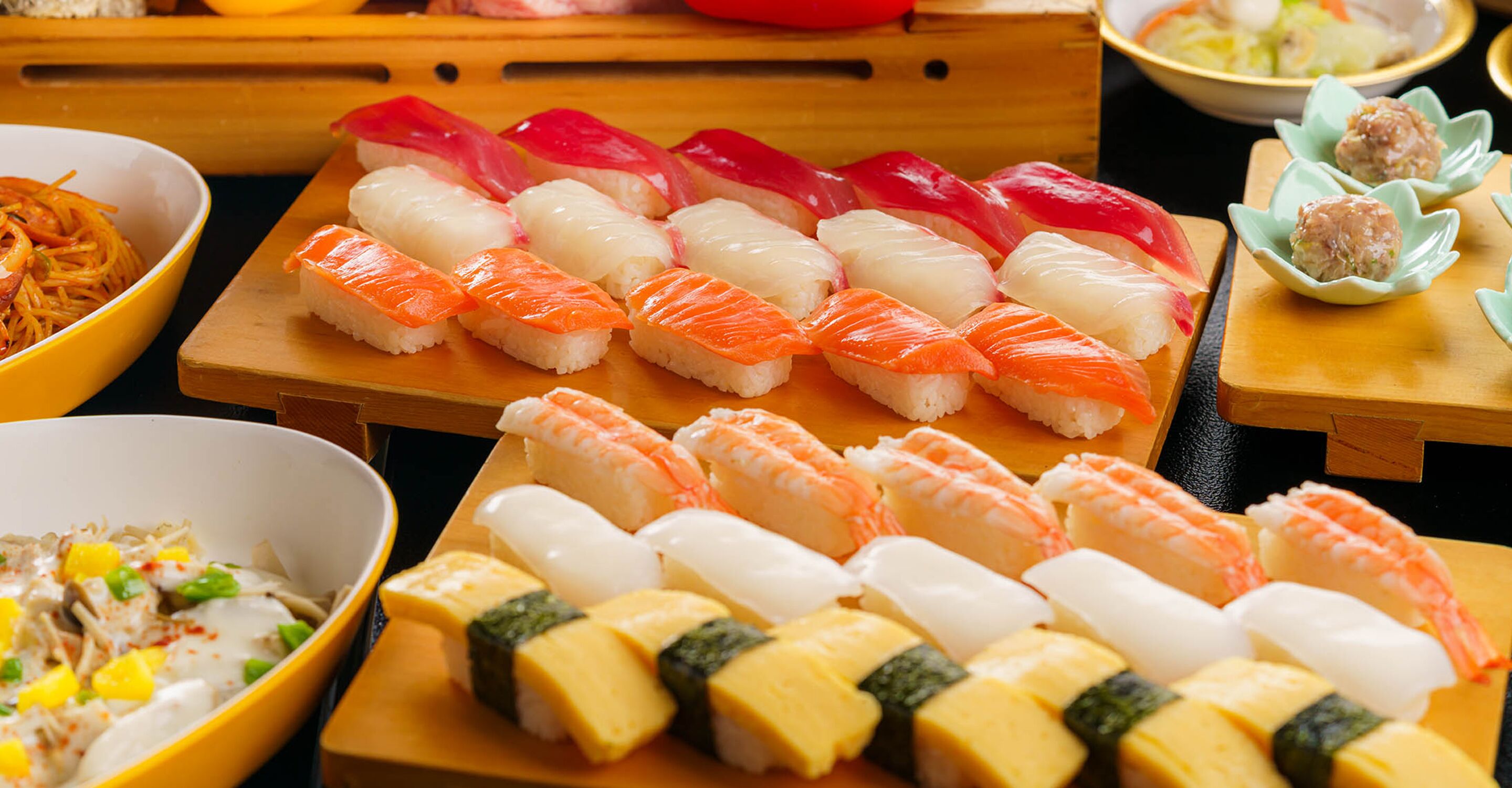 A variety of sushi dishes on wooden trays.