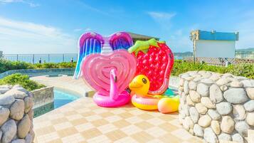 A pool area with inflatable decorations including a heart-shaped float and a strawberry float.